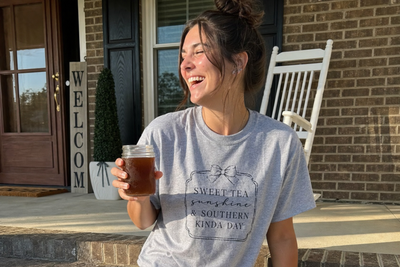 Customer wearing Southern saying tee on front porch